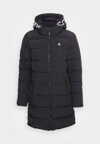 Černý prošívaný kabát s zipem, který má kapuci podšitou b�ílým textem s logem. Materiál má hladkou texturu a prošívaný design.