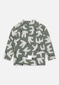 Camicia a maniche lunghe di colore verde oliva con modelli astratti di uccelli bianchi e dettagli blu navy; polsini elasticizzati e etichetta quadrata sull'orlo.