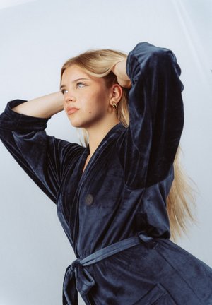 Navy blue velvet robe with wide sleeves, a belted waist, and a single button closure. Smooth texture with subtle sheen.