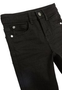 Čierne denim nohavice s stredne vysokým pásom, obsahujúce dve predné vrecká, kovové nitky a gombíkový uzáver, s hladkou textúrou.