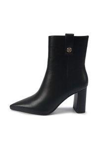 Botte de cheville en cuir noir avec un bout pointu, un talon block et un petit bouton décoratif en or sur la sangle latérale.