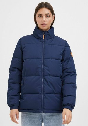 Veste rembourrée navy avec un col haut, fermeture éclair intégrale, poignets élastiques et accent en cuir beige sur la manche. Matériau lisse et résistant à l'eau.