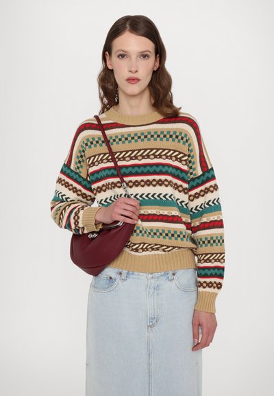 Maglione a maglia beige con motivi geometrici e a righe multicolori, abbinato a una gonna di jeans a vita alta e una borsa a spalla bordeaux.