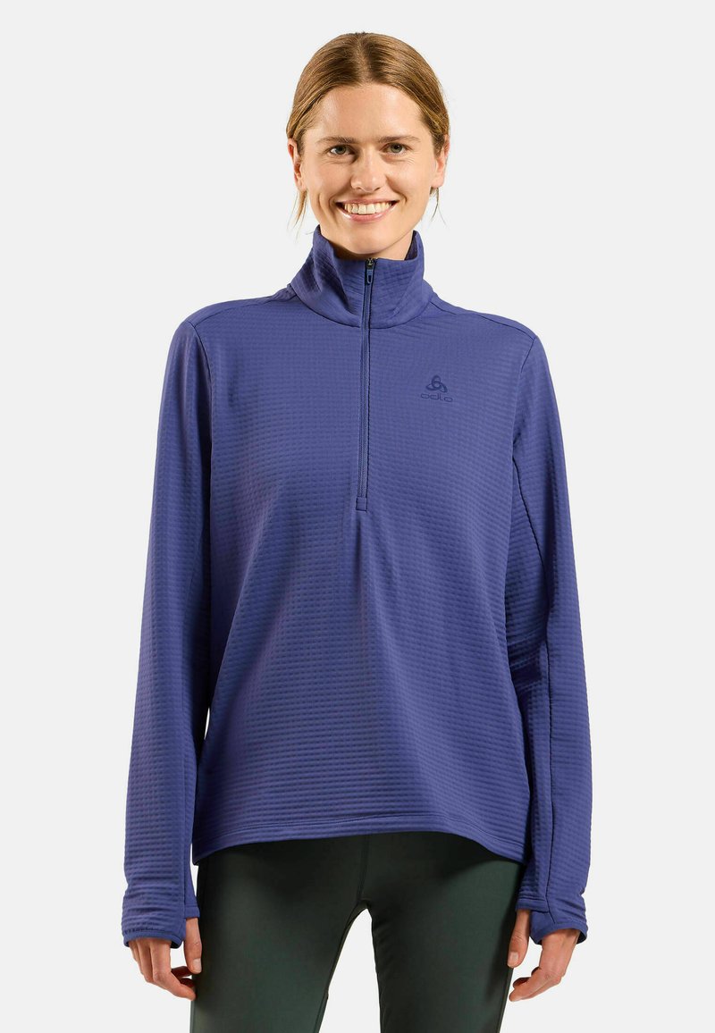 Purple quarter-zip top with a textured pattern, long sleeves, and thumbholes. Features a subtle logo on the front.