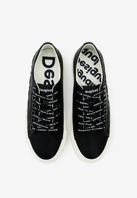Sneakers neri a punta bassa con suole in gomma bianca. La parte superiore presenta una finitura liscia con lacci stampati, mentre all'interno c'è un logo audace su uno sfondo in tessuto bianco.