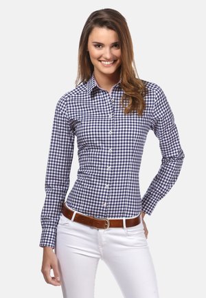 Chemise à carreaux bleu et blanc, à manches longues, au design ajusté et au col classique, assortie d'une ceinture marron et d'un pantalon blanc.