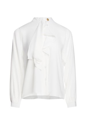 Hvid langærmet bluse med flæset frontdetalje og en lille gylden dekorativ knap ved den høje hals.