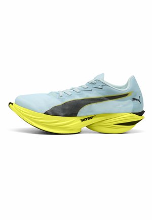 Zapatilla de correr azul claro con logo de Puma negro, suela gruesa y acolchada amarilla con la etiqueta "Nitro Elite" y diseño aerodinámico.