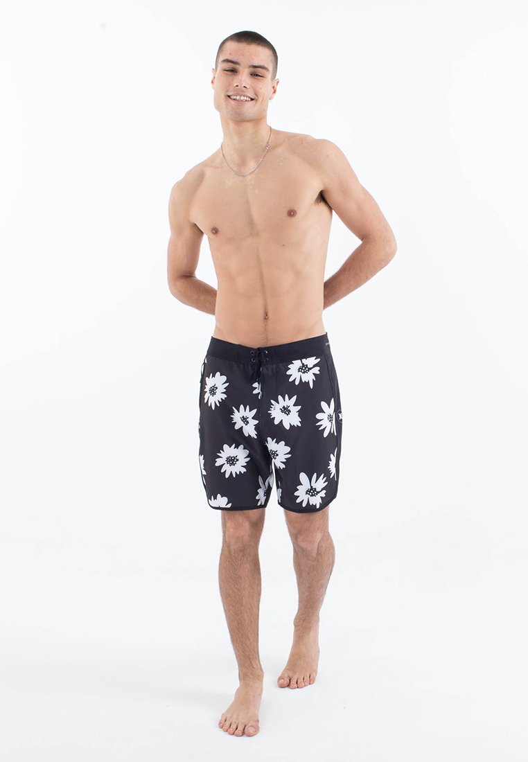 Maillots de bain noirs ornés de grands motifs floraux blancs, avec une taille à cordon et un tissu léger à séchage rapide.