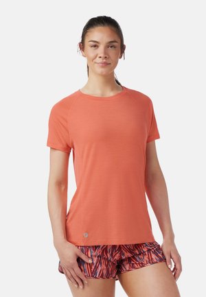 Coral athletic t-shirt, short sleeves, round neckline, smooth texture, relaxed fit, paired with multicolored patterned shorts.