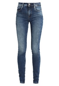 Jeans skinny de color azul oscuro con detalles desgastados y rasgados, cierre frontal con botón y diseño de cinco bolsillos.