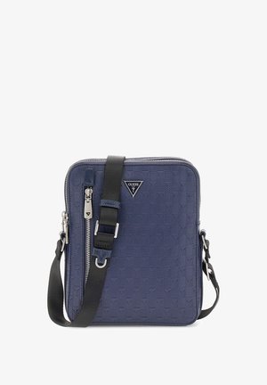 Tumedast sinine ruudukujuline ristiõlakott, valmistatud tekstuuritud materjalist, millel on lukuga sulgus, reguleeritav rihm ja esipaneelil logoplaat.