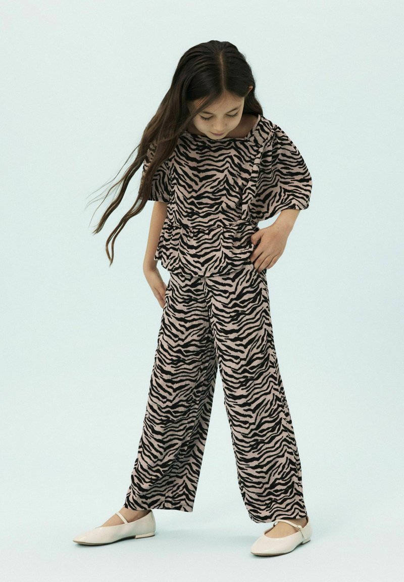 Zweiteiliger Outfit bestehend aus einem kurzärmeligen Oberteil und weit geschnittenen Hosen mit einem rosa und schwarzen Zebra-Print. Weicher, strukturierter Stoff mit lockerer Passform.