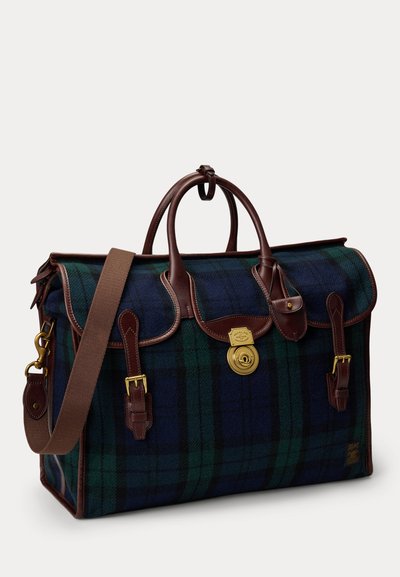Grande borsa da viaggio a quadri verde e blu navy con manici in pelle marrone, fibbie, tracolla e una serratura dorata sulla patta frontale.