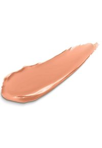 Fond de teint liquide crémeux dans une teinte pêche claire, texture lisse, appliqué en une fine ligne allongée avec une finition brillante.