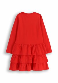Czerwona sukienka z długim rękawem, z trzema warstwami falbanek na dole. Gładka bawełniana tkanina z okrągłym dekoltem. Prosty krój, bez wzorów i ozdób.