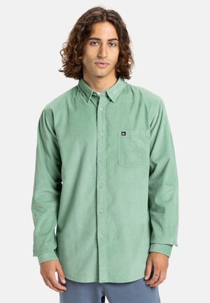 Lichtgroene ribfluwelen overhemd met een button-down kraag, lange mouwen, een enkele borstzak en een klein merklabel op de zak.