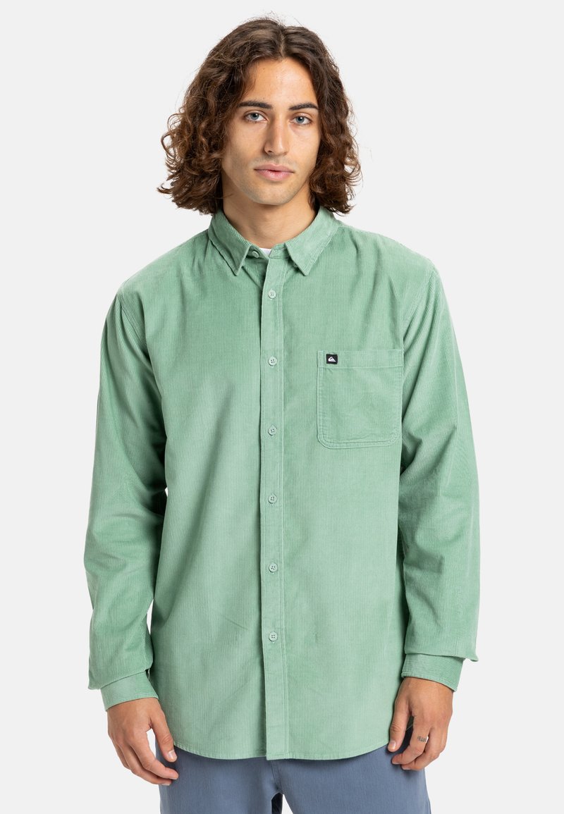 Lichtgroene ribfluwelen overhemd met een button-down kraag, lange mouwen, een enkele borstzak en een klein merklabel op de zak.