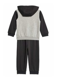 Tuta con cappuccio grigia e nera. La parte superiore presenta un corpo grigio con maniche nere, mentre i pantaloni sono completamente neri con polsini a costine.