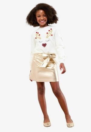 Witte pluizige trui met een rendiergezicht ontwerp, rode pompons en een hart. Metallic gouden rok met een strikdetail bij de taille.