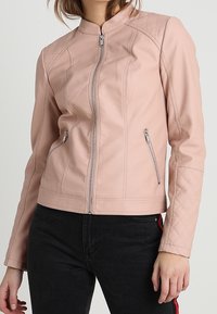 Giubbotto di pelle rosa chiaro con accenti trapuntati sulle spalle, vestibilità slim, colletto alto e zip argentate sulle tasche laterali.