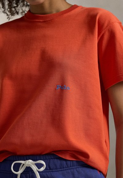 Κόκκινο βαμβακερό t-shirt με στρογγυλή λαιμόκοψη και κοντά μανίκια. Διαθέτει μπλε κεντημένο λογότυπο "Polo" στην αριστερή πλευρά. Μαλακή υφή.