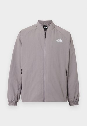 Veste gris clair zippée avec poignets élastiques et logo The North Face sur la poitrine gauche et près du col.