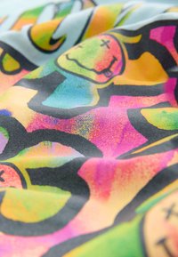 Buntes Gewebe mit abstrakten Mustern in leuchtenden Farbtönen von Pink, Grün, Gelb und Schwarz, mit glatter Textur und komplexen Designs.