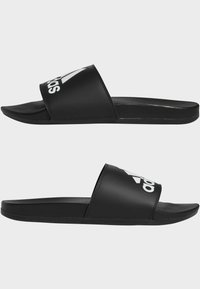 Černé skluzné sandály s hladkým matným povrchem. Široký pásek s bílým logem "adidas". Mírně zakřivená stélka a plochá podrážka.