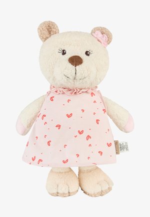 Plush teddy bear with beige fur, wearing a pink dress with red heart patterns and a pink flower on its left ear.