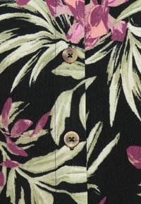 Tissu noir avec un motif floral vert et rose comportant trois boutons au centre. La texture semble douce avec un léger éclat.