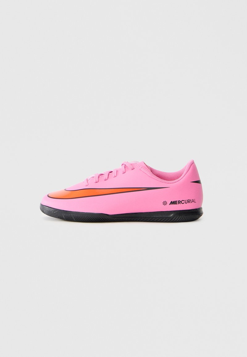Pink low-top Nike Mercurial soccer shoe with black sole and orange swoosh logo, side view on a plain light background.