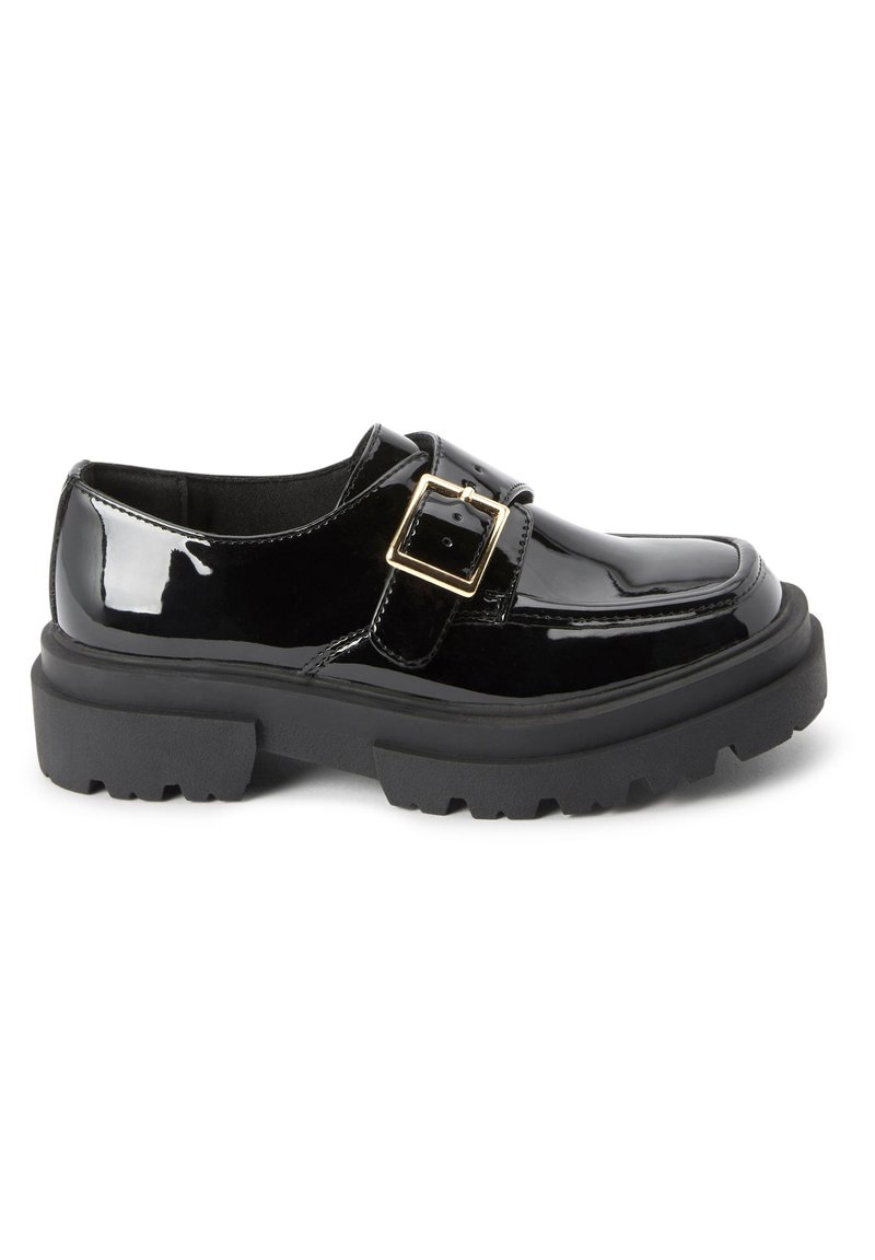 Scarpe in pelle verniciata nera con una suola spessa nera, dotate di una fibbia decorativa e una superficie liscia e lucida. Design con punta arrotondata.