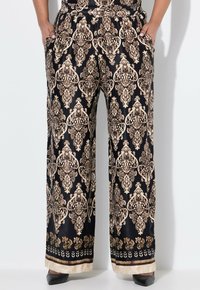 Zwarte wijde broek met een gouden damask patroon, elastische tailleband en zijzakken. Afgewerkt met een contrasterende bloemenrand aan de onderkant.