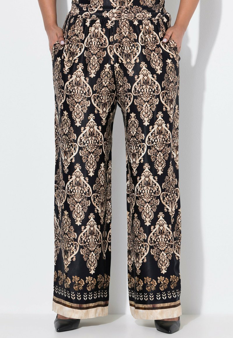 Zwarte wijde broek met een gouden damask patroon, elastische tailleband en zijzakken. Afgewerkt met een contrasterende bloemenrand aan de onderkant.