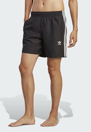 Pantaloni da bagno neri con un elastico in vita, dotati di strisce laterali bianche e di un logo ricamato sulla coscia sinistra. Tessuto leggero.