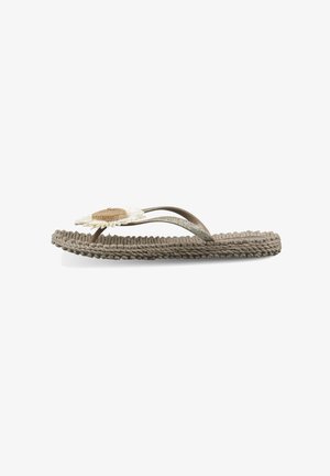 Beige flettet sål flip-flop med tynde glitrende stropper og en dekorativ hvid og lys brun blomst på toppen.