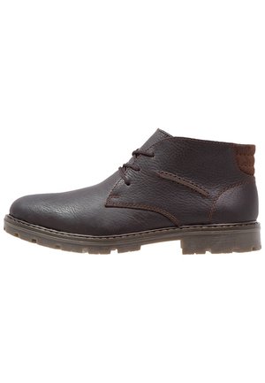 Bottes chukka en cuir marron avec un bout rond, un design à lacets, un empattement texturé et une semelle en caoutchouc. Présente des accents marron contrastants au niveau du talon.