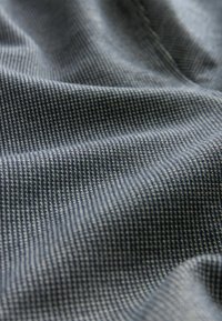 Tejido texturizado en azul marino con un patrón de cuadrícula. El material parece suave y ligeramente elástico, mostrando hilos finos y levantados.
