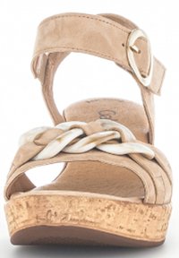 Beżowe sandały na koturnie z korkową podeszwą, plecionym paskiem z przodu oraz paskiem wokół kostki z okrągłą klamerką.