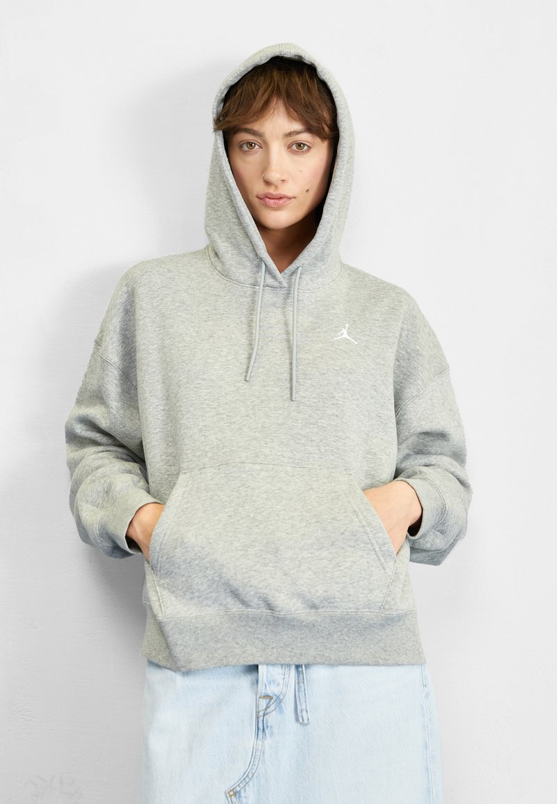 Szürke kapucnis pulcsi állítható zsinórokkal, nagy elülső zsebbel és a mellkason fehér Jumpman logóval. Puha tapintású és kényelmes szabású.