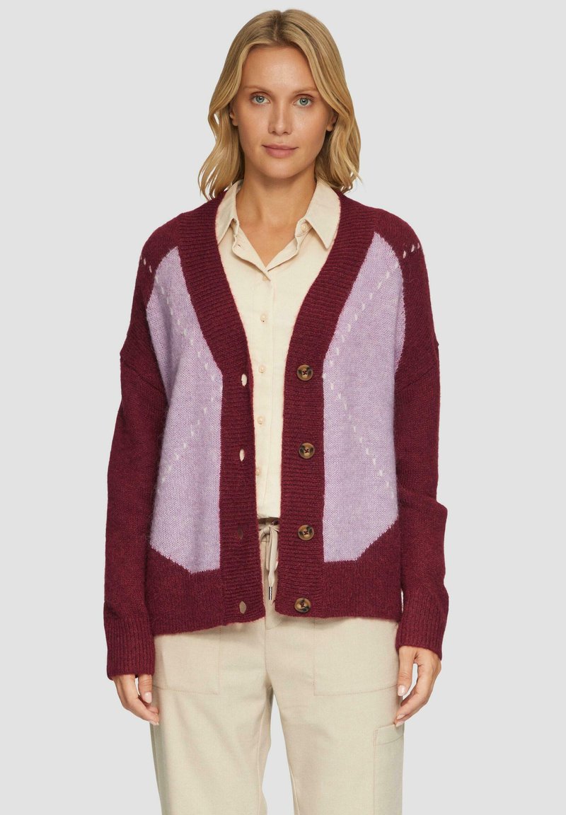 Gestrickte Strickjacke in Maroon- und Lavendelfarben. Sie hat eine lockere Passform, eine auffällige Knopfleiste und ein Rautenmuster auf den Schultern.