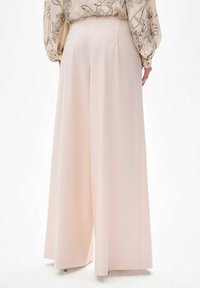 Brede pantalon in een zachte, lichtroze stof. Kenmerkt zich door een soepele textuur en een geplande uitstraling met een hoge taille en keurig afgewerkte naden.