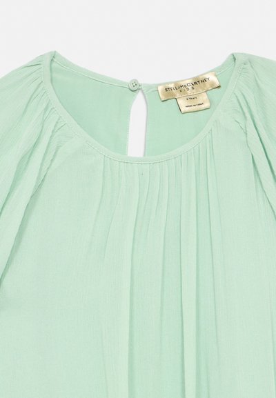 Világoszöld gyermek blúz összehúzott szövet részletekkel, kerek nyakkivágással, hátul gombos záródással és Stella McCartney Kids címkével.