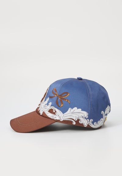 Casquette bleue et marron avec un visière marron, ornée de motifs floraux blancs délicats et d'un détail de nœud marron à l'avant.