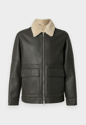 Tumši zaļa ādas jakas, ar bežīgu mākslīgo vilnas apkakli, rāvējslēdzēja aizdari un divām priekšējām kabatām. Gluda tekstūra, ikdienišķs dizains.