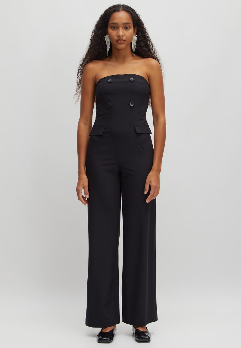 Zwarte strapless jumpsuit met dubbelknopen, zijzakken en wijde benen. Soepele stof en een nauwsluitende pasvorm.