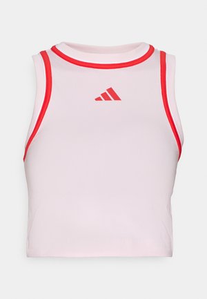 Un top court de sport blanc avec un col et des emmanchures côtelés rouges, arborant un logo Adidas rouge centré sur la poitrine. Texture de tissu lisse.