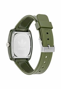 Adidas armbandsur med olivgrön silikonrem, fyrkantig baksida i rostfritt stål och metallspänne med märkeslogotyp.