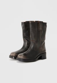 Sorte lær ankle boots med en lett hevet hæl, med en jevn tekstur, rund tå og kontrasterende sømdetaljer.